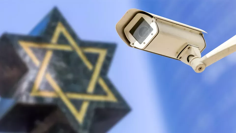 A photo of a security camera in front of a star of David.