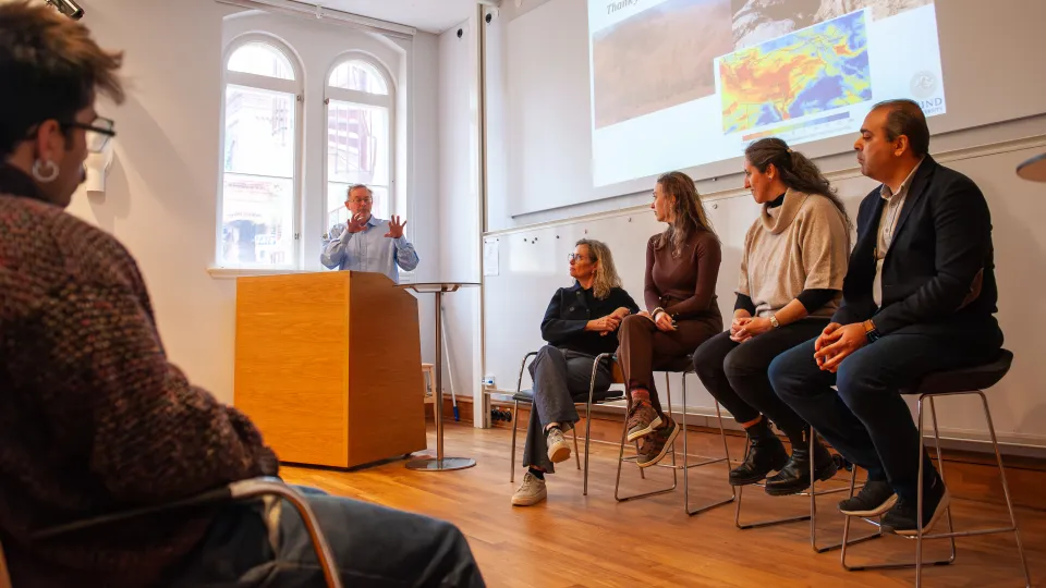 The panel members sitting in a row looking slightly to their right towards Ronny the moderater.