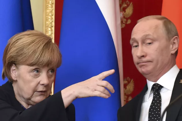 A photo of Angela Merkel pointing her finger as Vladimir Putin looks at her.