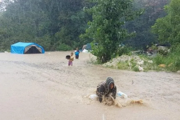 Migrant farmer struggle in a flood in their camp